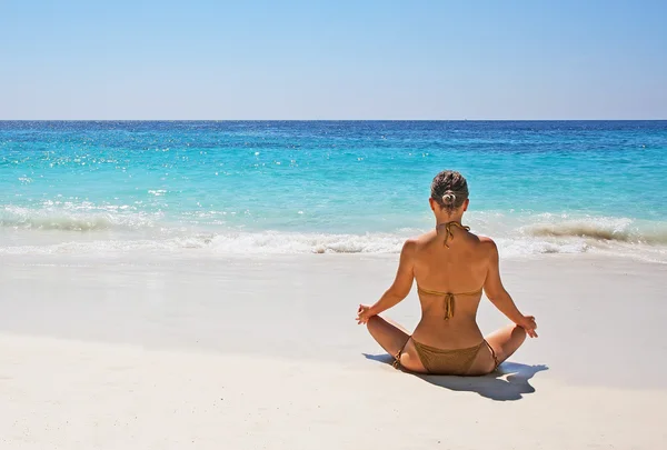 Schöne Mädchen im Bikini sitzt in Lotus-Pose — Stockfoto