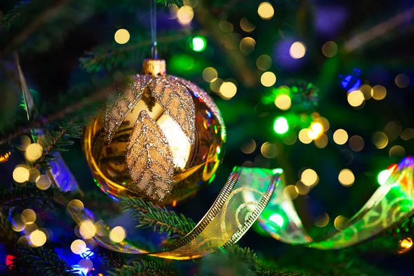 在圣诞树上把金球关上 圣诞树 装饰在黑暗的背景上 灯火通明 圣诞树上的圣诞装饰品 — 图库照片