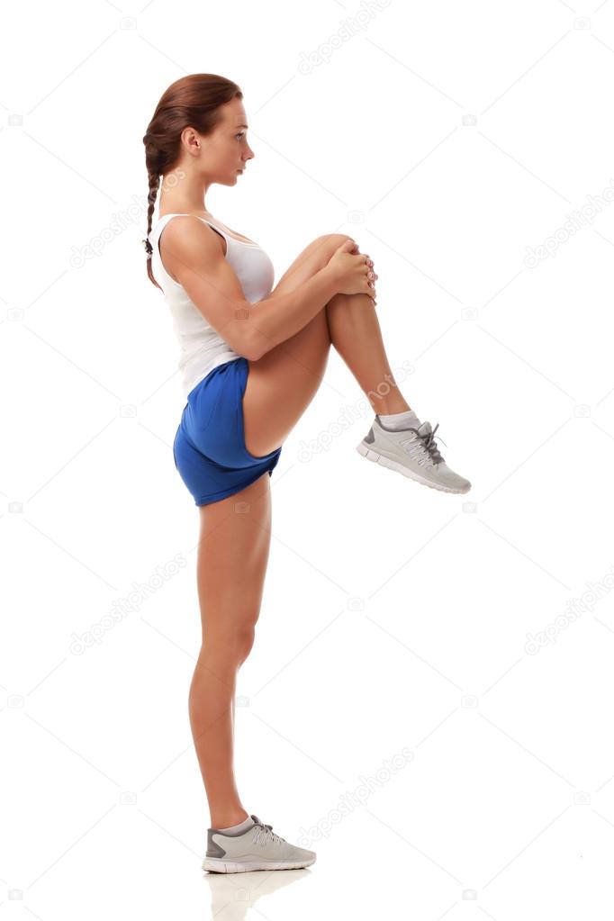 Young attractive fitness model stretching knee