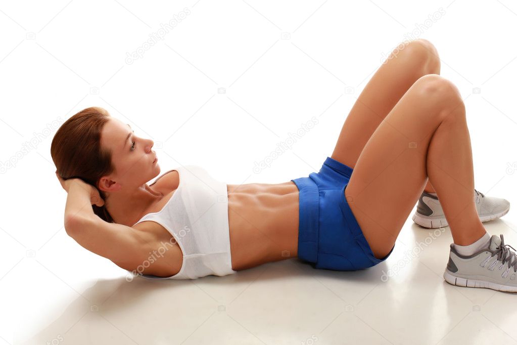 Young attractive fitness model performing abdominal exercises