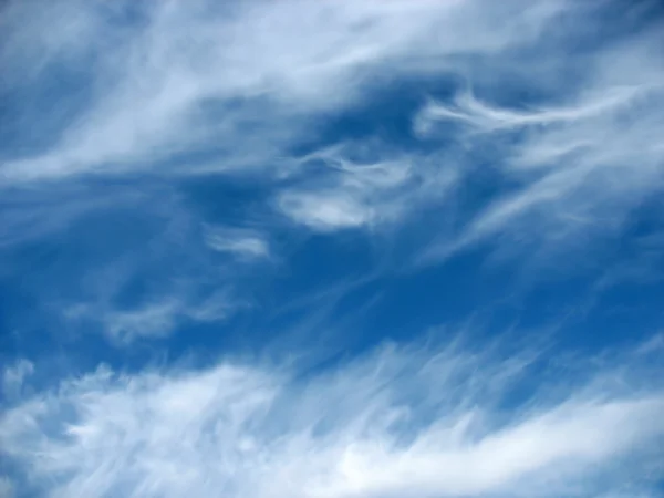 Blue sky background with wavy fleecy clouds — Stock Photo, Image