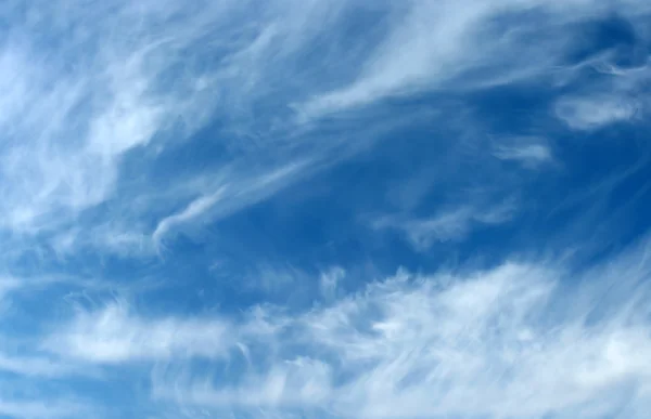 Fondo de cielo azul con nubes onduladas y vellosas — Foto de Stock