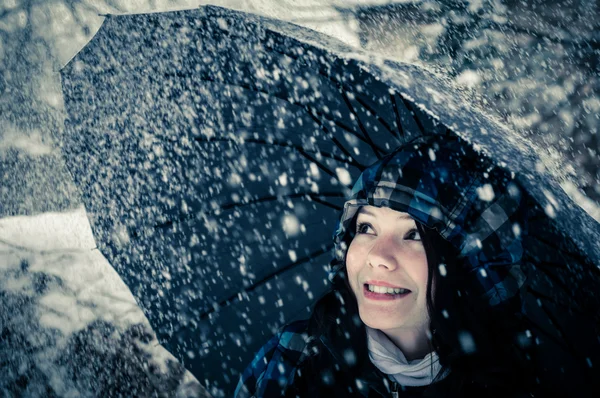 Jonge vrouw met paraplu in een sneeuwstorm — Stockfoto