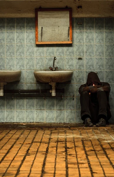 Een verlaten industriële interieur met een depressief man — Stockfoto