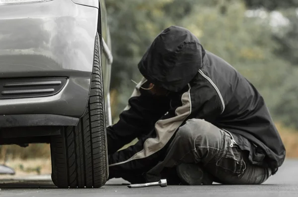 Młody człowiek naprawy samochodu na zewnątrz. — Zdjęcie stockowe