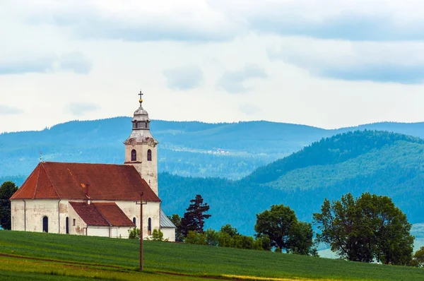 Liten kyrka med blå bergen — Stockfoto