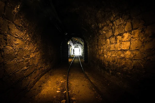 Passagem de mina subterrânea com trilhos — Fotografia de Stock