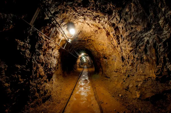 Underjordiska gruva passage med skenor Royaltyfria Stockfoton