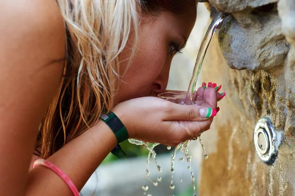 Žízeň dívka pití z venkovní vodovodní — Stock fotografie