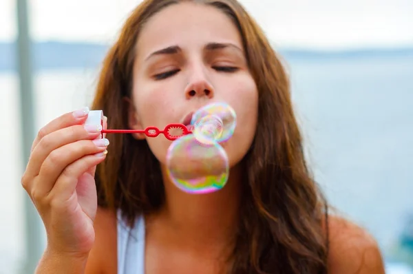 Young woman blowing bubbles — Stock Photo, Image
