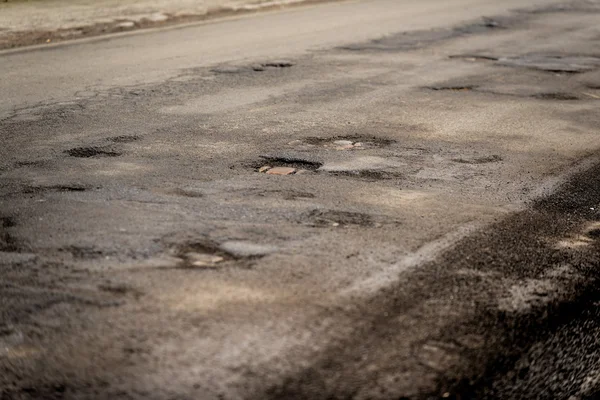 Поврежденная автомобильная дорога с большим количеством трещин — стоковое фото