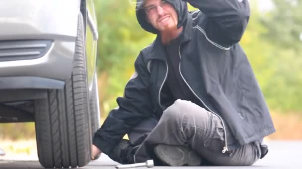 Hombre arreglando un coche en la carretera — Vídeo de stock
