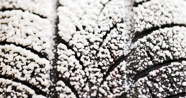 Sníh padající na zimní pneumatiky detailní záběr — Stock fotografie