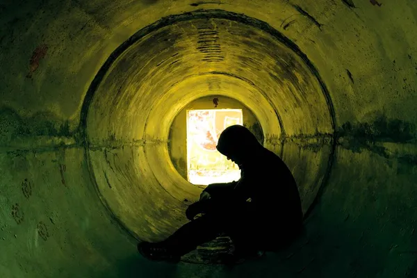 Homem sentado no túnel subterrâneo de concreto — Fotografia de Stock