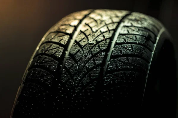 Neumáticos limpios del coche girando sobre fondo oscuro — Foto de Stock