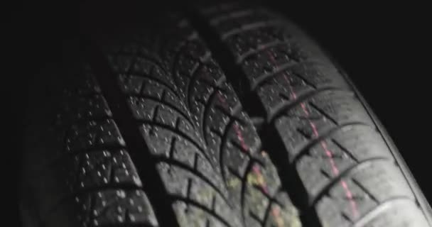 Neumáticos limpios del coche girando sobre fondo oscuro — Vídeo de stock