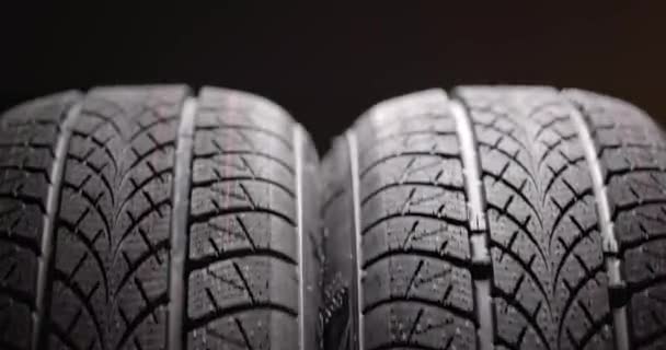 Clean car tyres spinning against dark background — Stock Video