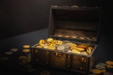 Heap of coins in small wooden chest clipart