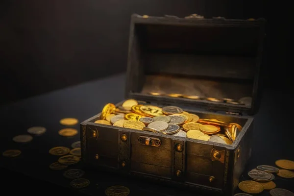 Haufen Münzen in kleiner Holzkiste — Stockfoto