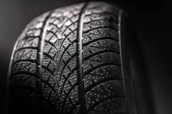 어두운 배경에서 회전하는 깨끗 한 자동차 타이어 — 스톡 사진