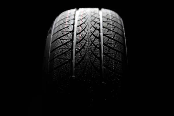 Čisté auto pneumatiky rotující na tmavém pozadí — Stock fotografie