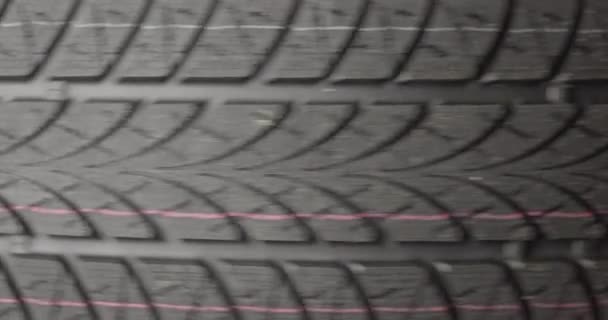 어두운 배경에서 회전하는 깨끗 한 자동차 타이어 — 비디오