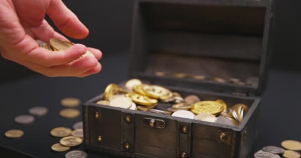 Рука положить монеты в сундук сокровища замедленной съемки — стоковое видео