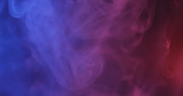 Siyah arkaplanda kırmızı ve mavi renkli duman — Stok fotoğraf