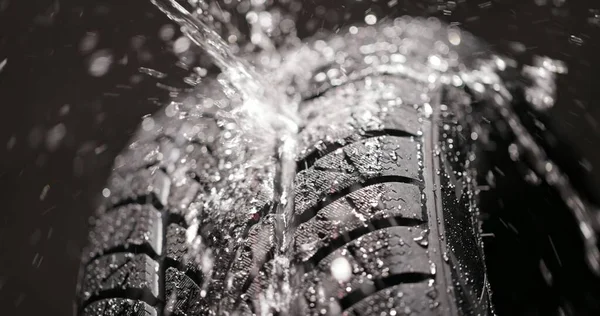 Water splashing on new car tyre closeup — Stock Photo, Image