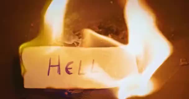 Closeup Video Burning Paper Hell Written — стоковое видео