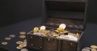 Money falling into treasure chest in slow motion closeup clipart