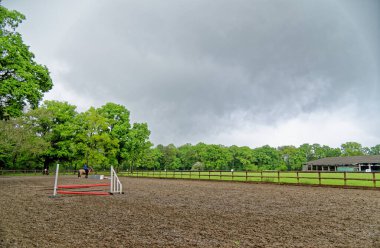 Genç kız ilk binicilik dersini kaskı ve eğitmeniyle birlikte eyersiz olarak alıyor. Wellington Binicilik Okulu, Hook, Birleşik Krallık. 11 Mayıs 2016