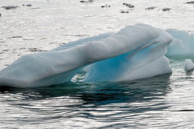Antarktika - Okyanusta sürüklenen Tablo Olmayan Buzdağı - Bulutlu bir günde Antarktika. Küresel sıcaklık