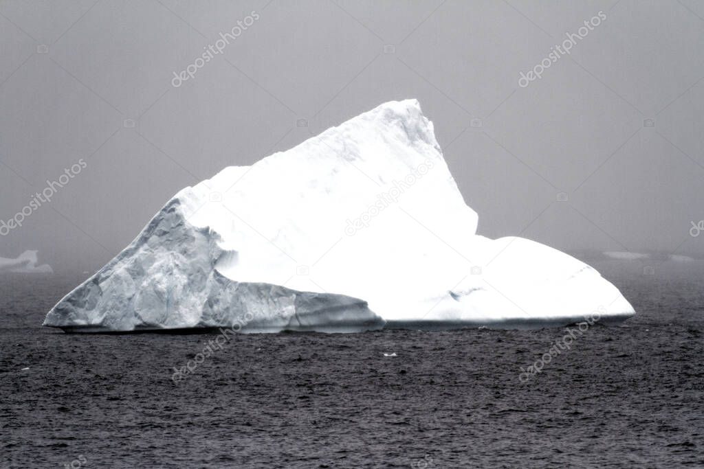 Antarctica - Non Tabular Iceberg Drifting In The Ocean - Antarctica In A Cloudy Day. Global warming