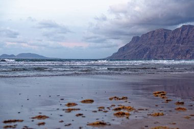 Plaj Playa de Famara ve dağ sırası akşam ışığında Risco de Famara, Lanzarote, Kanarya Adaları, İspanya, Avrupa