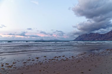 Plaj Playa de Famara ve dağ sırası akşam ışığında Risco de Famara, Lanzarote, Kanarya Adaları, İspanya, Avrupa