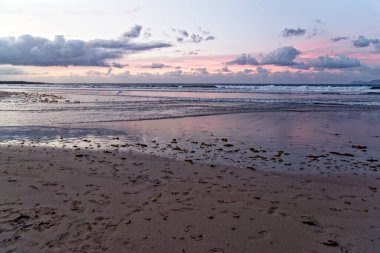 Famara Sahili 'nde günbatımı. Lanzarote Kanarya Adaları Caleta de Famara, Famara Sahili Rüzgar sörfü ve akşam güneşinde sörf plajı.