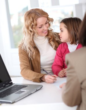 Woman in real-estate agency with kid