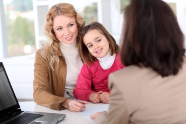Woman in real-estate agency with kid