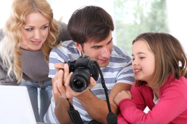 fotoğraf makinesi ekranında fotoğraflara bakarken aile