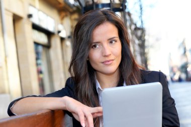 tablet ile ortak bankta oturan kadın
