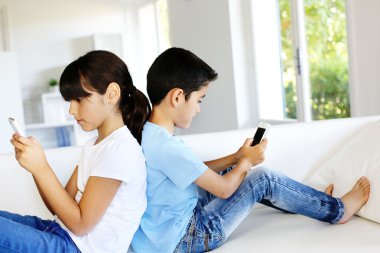 evde akıllı telefonlar ile oynayan çocuklar