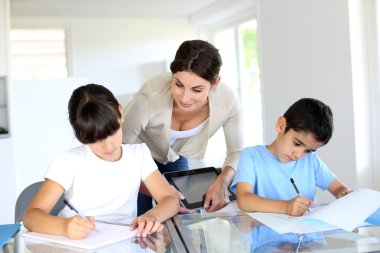 öğretmen ve defter üzerinde yazma sınıfta çocuklar