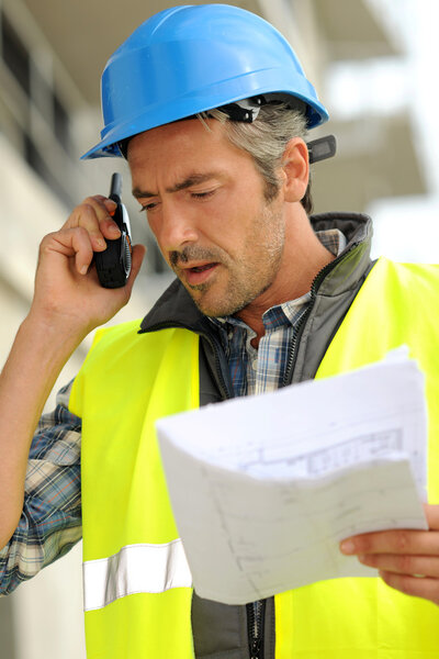 Portrait of construction manager using walkie-talkie