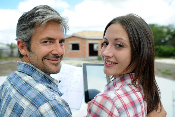 Couple standing in front of their future home — Stock Photo, Image