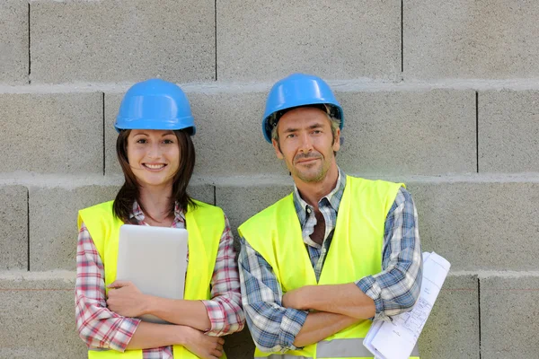 Retrato del equipo de construcción sonriente de pie en la pared de hormigón —  Fotos de Stock