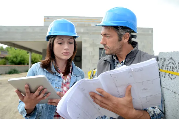 Plano de leitura da equipa de construção no local — Fotografia de Stock