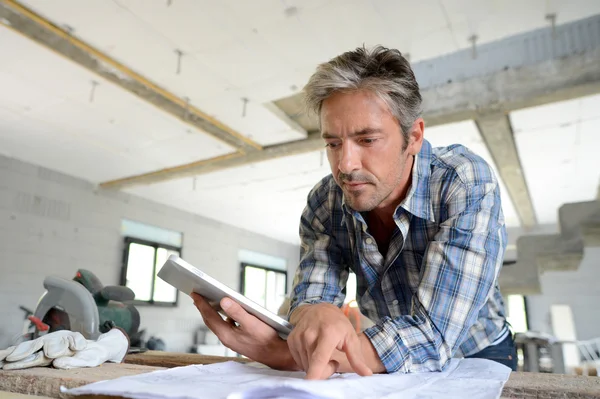 Empreendedor em casa em construção plano de verificação — Fotografia de Stock