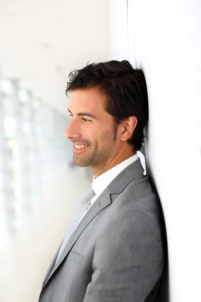 Бізнесмен стоїть на білому фоні стіни профілю — стокове фото