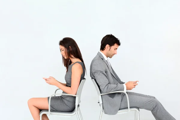 Business sitting in chairs with mobile phone — Stock Photo, Image